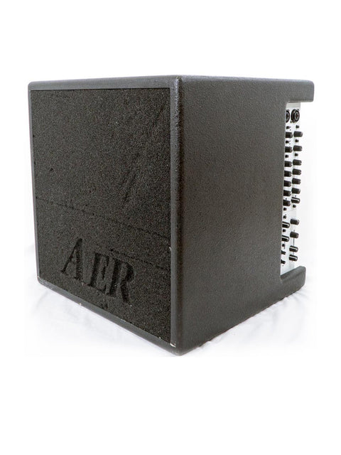 Angled side view of the AER Bass Cube 2 amplifier, displaying the sleek black casing and ergonomic design.