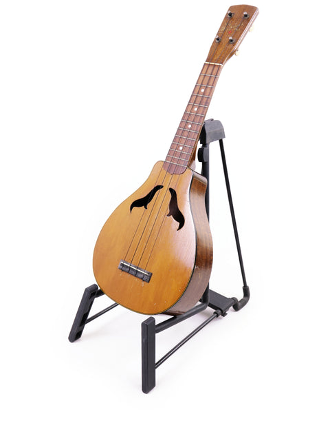 Beautifully showcased 1927 Harmony Roy Smeck Vita-uke ukulele on a stand, a must-have for any serious ukulele enthusiast.