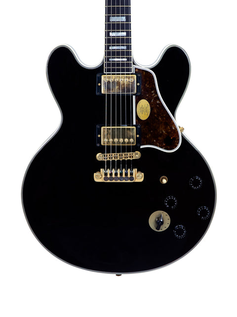 Black electric guitar featuring a gold pickguard, autographed by BB King and Eric Clapton, highlighting its collectible value.
