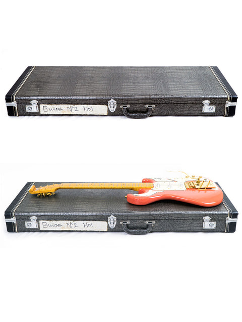 Black guitar case closed on top and open with a red guitar on the bottom.