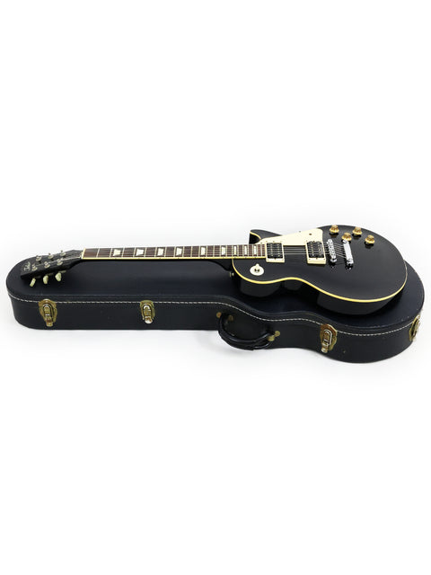 Black guitar case with gold hardware, featuring a Tokai Les Paul Reborn LS50 from Japan, 1979.