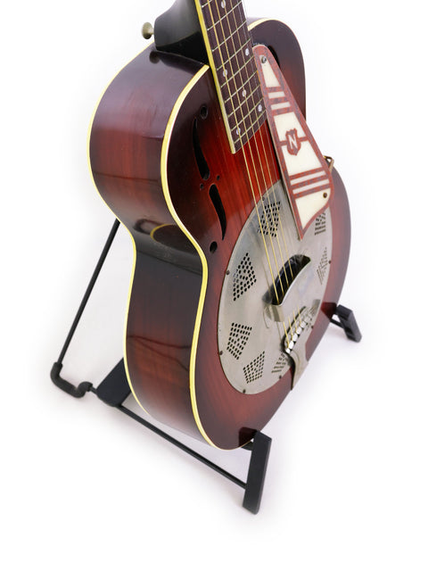 Classic 1937 National Trojan Resonator guitar resting on a stand, set against a bright white background.