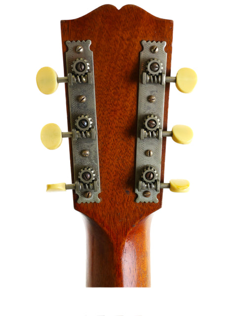 Close-up of a 1920 Vintage Gibson L-1 headstock with four knobs, representing timeless acoustic guitar design.