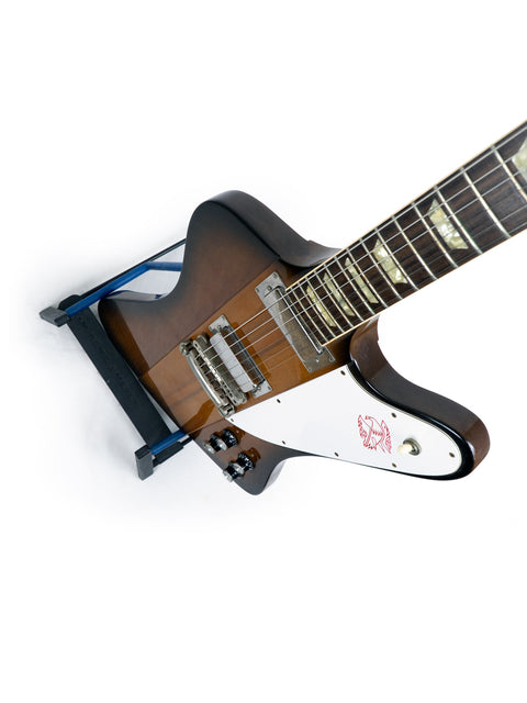 Close-up of a 1991 Gibson Firebird V Reissue guitar showcasing its wooden body and vibrant blue pick guard.