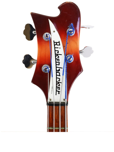 Close-up of a 1997 Rickenbacker 4003 Fireglo bass head, highlighting its logo and classic craftsmanship.