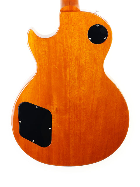Close-up of a 2013 Gibson Les Paul Standard guitar featuring a wooden body and sleek black buttons.