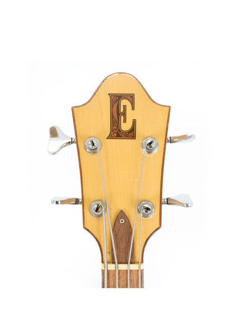 Close-up of the headstock of a vintage 1980s Ernie Ball Earthwood Bass, highlighting its distinctive design and quality.

