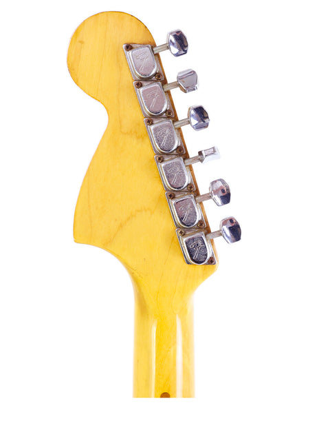 Close-up shot of a yellow-bodied vintage Fender Stratocaster guitar head from 1979.