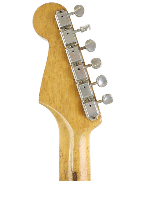 Detailed view of a 1958 Fender Stratocaster guitar head, highlighting the rich wood grain and vintage craftsmanship.