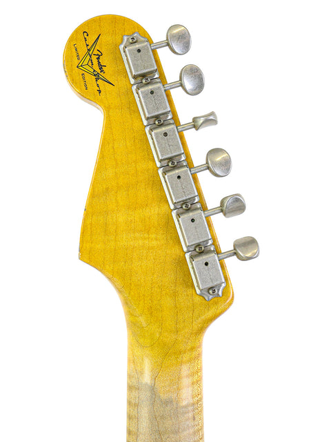 Detailed view of a yellow-bodied Fender Ltd NAMM '64 Stratocaster Relic guitar head, highlighting its craftsmanship and design.