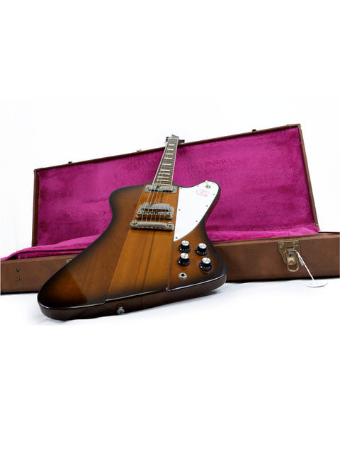 Gibson Firebird V Reissue guitar in a purple case, showcasing its sleek design and vibrant color.
