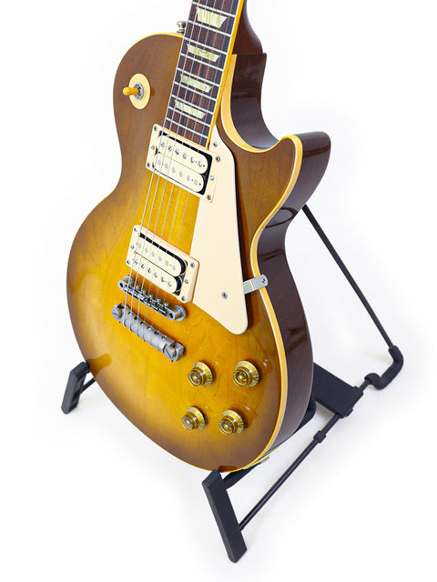 Gibson Les Paul Classic 1960 Reissue guitar rests elegantly on a stand, showcasing its iconic design and craftsmanship.