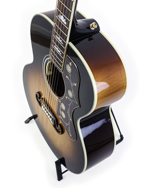 Gorgeous Gibson SJ-200 guitar on a stand, emphasizing its design against a white background. Perfect addition for guitar enthusiasts.