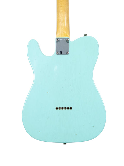 Green Fender Custom Shop 60s Journeyman Telecaster guitar featuring a wooden body and neck, highlighting its craftsmanship.
