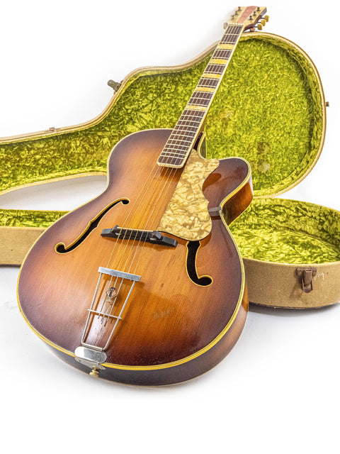 Green case containing a vintage Hofner 455 Archtop guitar from the 1950s, representing classic German guitar design.