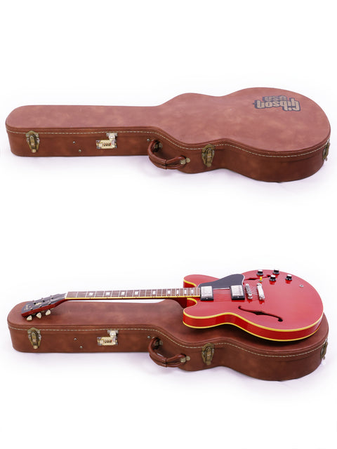 Inside a case, a red Gibson ES-335 Block 1963 guitar is displayed on top of two guitars, emphasizing its iconic design.