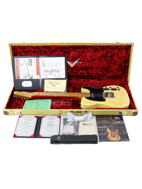 Inside a guitar case, a Fender Broadcaster and picks are neatly arranged, highlighting the 70th Anniversary edition.