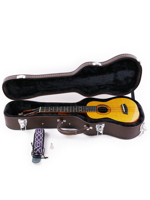 Inside a guitar case, a Kanile’a Platinum Limited Edition Super Concert Ukulele and a microphone are displayed, representing Hawaii 2017.