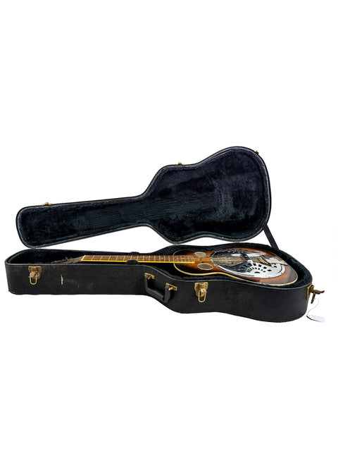 Inside a vintage Regal Dobro guitar case from the 1930s, a beautifully preserved guitar rests, reflecting its rich heritage.
