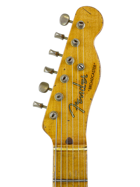 Left view of a 1961 Fender Stratocaster, highlighting its iconic shape and color, with a 2020 Broadcaster in the background.