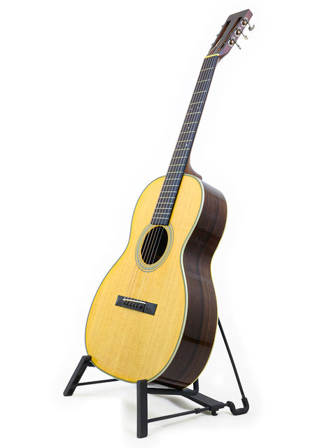 Martin 00-28VS guitar displayed on a stand, set against a bright white background, highlighting its craftsmanship.
