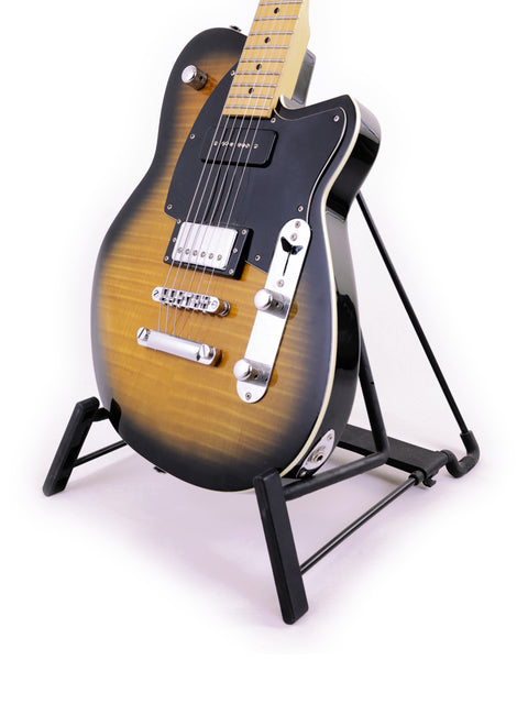 Reverend Double Agent guitar displayed on a stand, contrasting beautifully with a deep black background.
