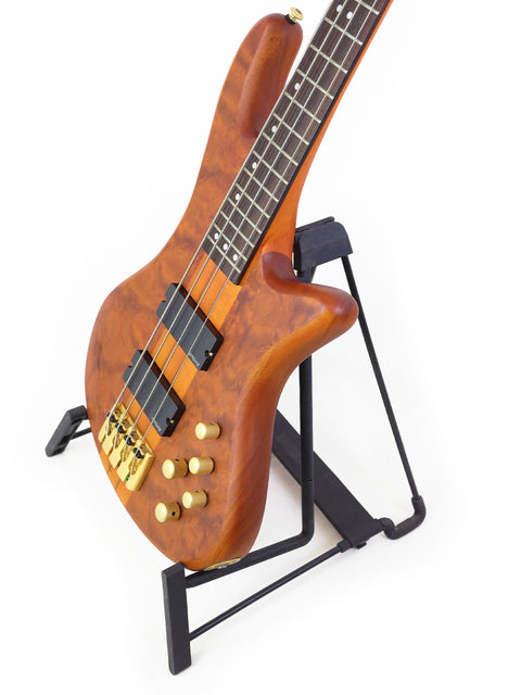 Schecter Stiletto Studio 4 bass guitar elegantly displayed on a stand, with a minimalist white background highlighting its features.
