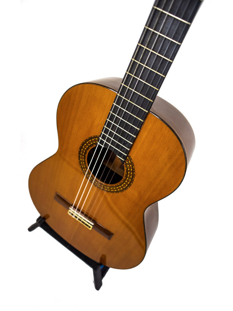 The Alhambra C-Series ORO classical guitar from Spain, 2005, elegantly displayed on a stand with a white background.