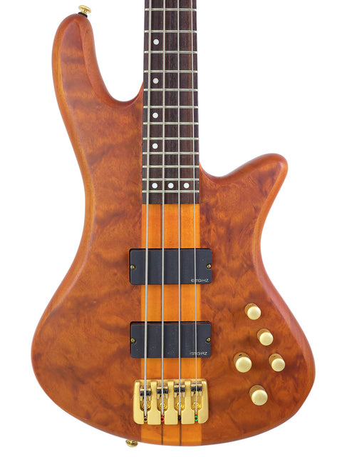 The Schecter Stiletto Studio 4 bass guitar boasts a wooden body and a stylish black pickguard, perfect for any musician.