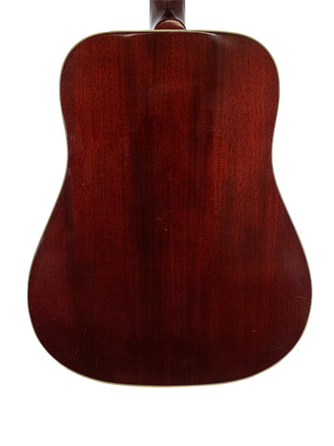 The back of a 2012 Gibson Hummingbird True Vintage acoustic guitar, highlighting its elegant design and fine wood details.