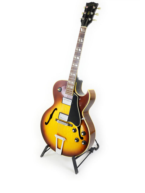 The iconic Gibson ES-175D guitar from the 1970s rests on a stand, highlighting its timeless craftsmanship and style.