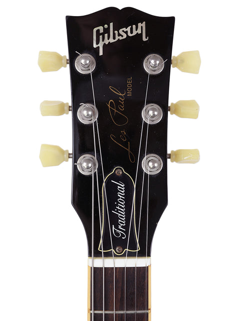 The image features a 2009 Gibson Les Paul Traditional electric guitar, highlighting its iconic shape and craftsmanship.

