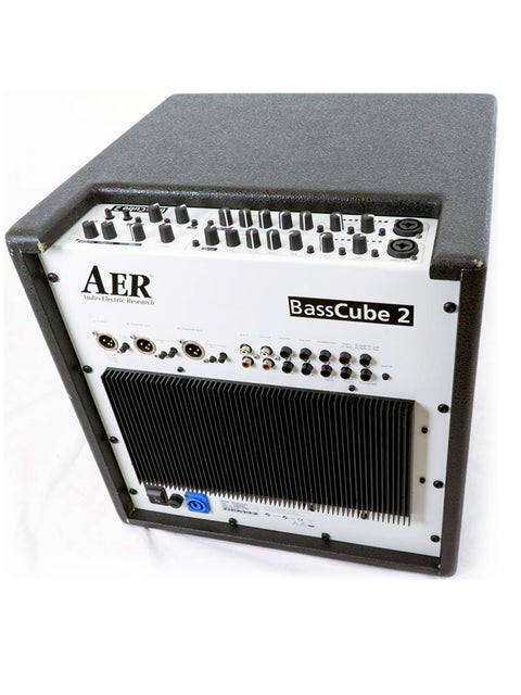 Top-down angle of the AER Bass Cube 2 amplifier showing detailed controls and sturdy casing.