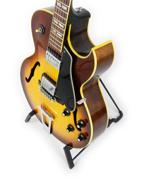 Vintage Gibson ES-175D guitar from the 1970s elegantly positioned on a stand with a white backdrop.