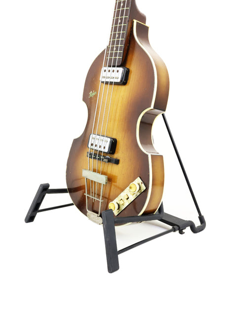 Vintage Hofner 500/1 'Beatle Bass' guitar on a stand, featuring a strap, highlighting its classic German craftsmanship from 1962.