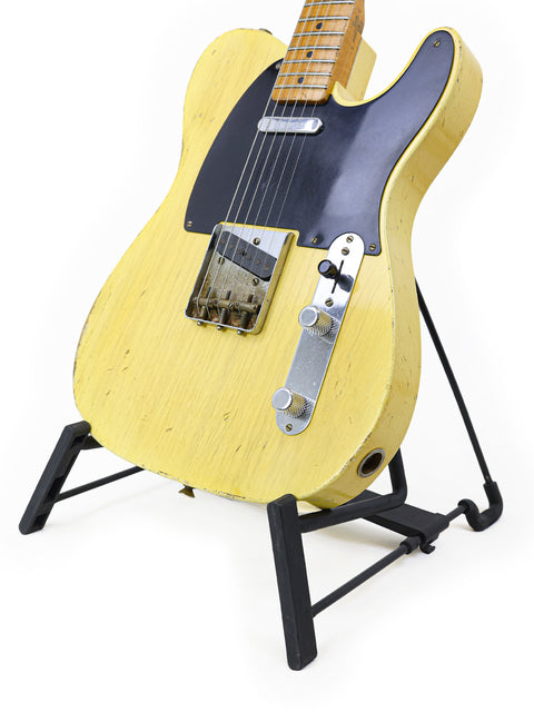 Yellow Fender guitar displayed on a black stand, marking the 70th Anniversary of the Broadcaster, USA 2020.