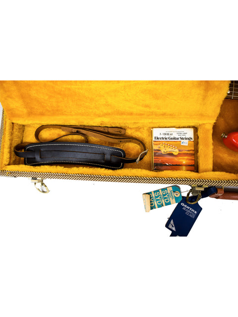 Yellow case with a key chain and key, showcasing a 1996 Fender American Vintage 62 Strat in vibrant Fiesta Red.
