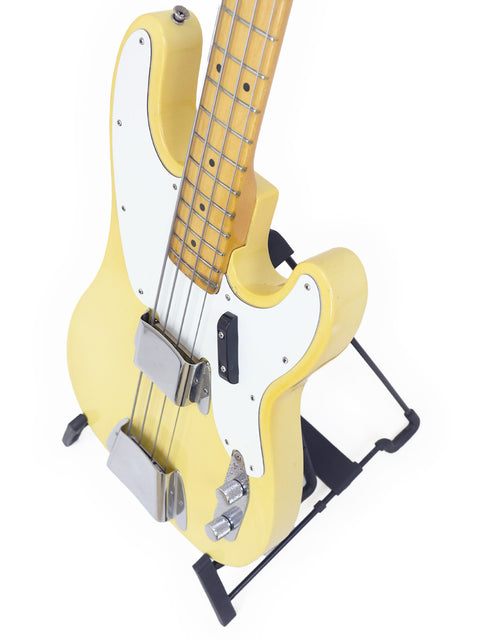 Yellow electric bass guitar, a 1968 Fender Telecaster, elegantly positioned on a stand, emphasizing its vintage style.
