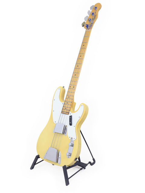Yellow electric guitar, a 1968 Fender Telecaster Bass, showcased on a stand.