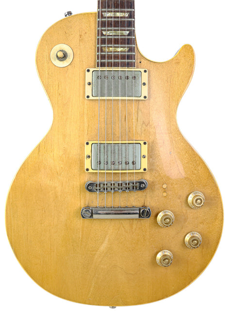 Yellow vintage Gibson Les Paul Deluxe electric guitar from 1973, displayed on a white background.