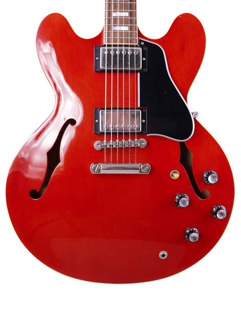 vibrant red Gibson ES-335 electric guitar with a black pickup, highlighting its vintage 1963 design from the Nashville Custom Shop.