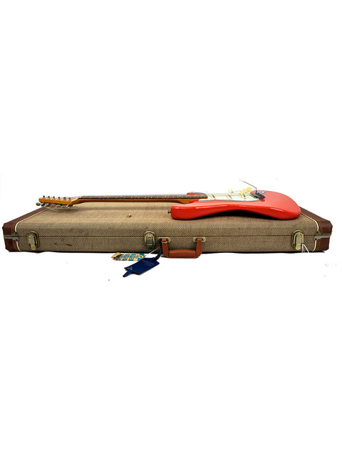vibrant red guitar case featuring a wooden handle, containing a 1996 Fender American Vintage 62 Strat in Fiesta Red.