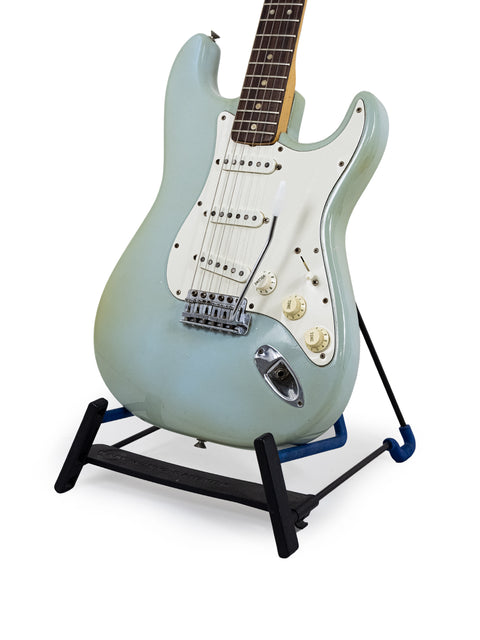 vintage 1972 Fender Stratocaster guitar with a white body displayed on a stand, marked as sold.
