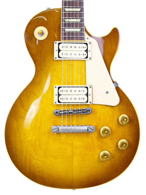 yellow Gibson Les Paul Classic 1960 Reissue guitar with a white pickguard, showcasing its vibrant color and classic design.